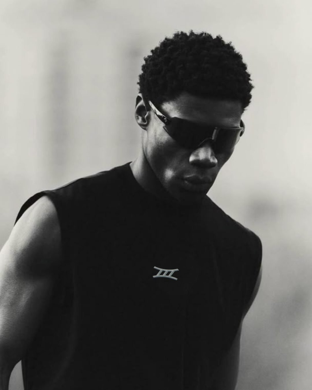 Portrait en noir et blanc d'un athlète portant des lunettes et le logo Haem
